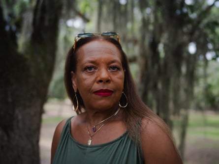 A photo of a woman posing in front of trees