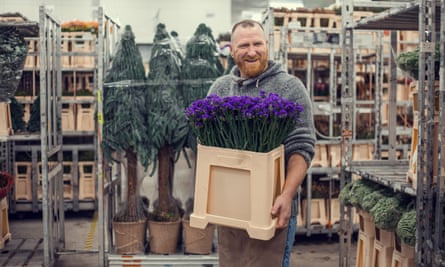 A male manual worker on duty working in Europe at a flower and plant warehouse facility