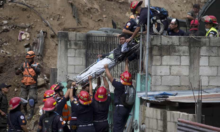 A volunteer is carried on a stretcher by firemen after he was injured while helping rescue workers at the site of a landslide in Cambray 10 miles east of Guatemala City on Saturday.