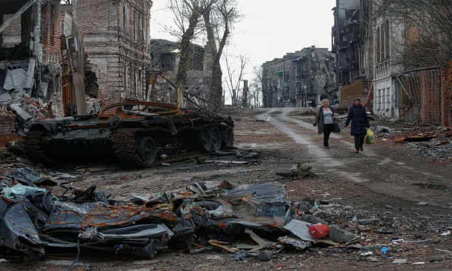 Russia-Ukraine war latest: Zelenskiy warns Moscow wants to ‘capture other countries’ as Russia pushes to seize southern Ukraine– live | Ukraine 4 People walk near a destroyed tank and damaged buildings in Mariupol.