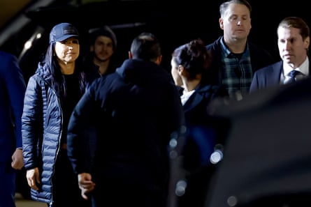 Woman dressed all in black in bright light surrounded by people.