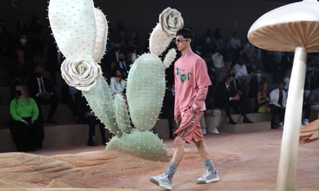 A model walks between mushrooms and cacti on the runway during the Dior Homme menswear spring/summer 2022 show