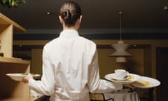Waitress carrying dirty plates in restaurant, rear view