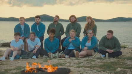 The participants from series two of Virgin Island, sitting on a beach.