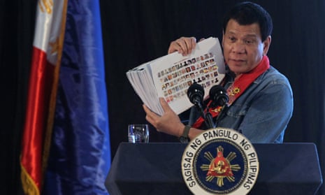 Philippine president Rodrigo Duterte holds a compilation of pictures of people involved in drugs