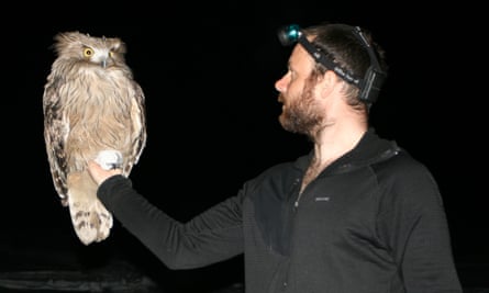 Jonathan Slaght holds a male fish owl in Primorye, Russia, in 2007.