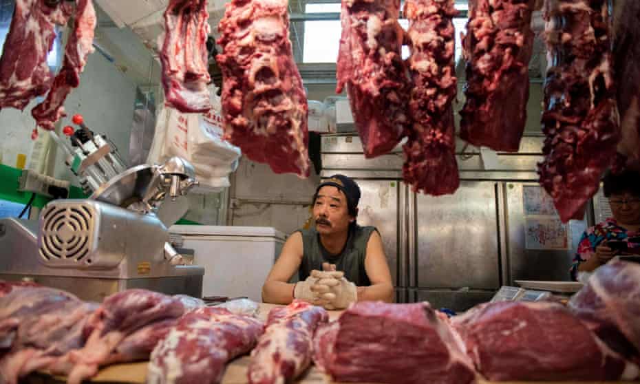 A butcher waits for customers at his stall in a Beijing market.
