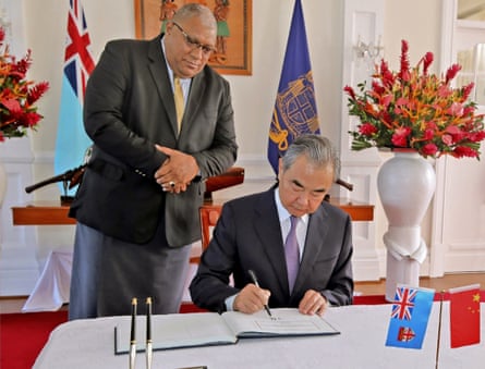 The president of Fiji, Ratu Wiliame Katonivere, watches as Chinese foreign minister Wang Yi signs the visitors book in Suva on Monday.