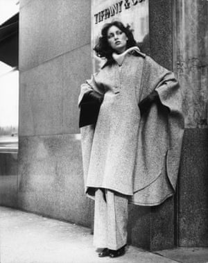 Black and white photo of model wearing wool cape and pants ensemble