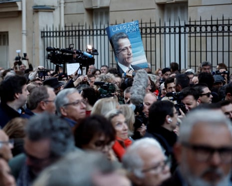 A supporter holds a poster with a portrait of Nicolas Sarkozy and the slogan “Strong France” as they attend a gathering called by the sons of former French president Nicolas Sarkozy in support of their father in Paris, France, 21 October 2025.