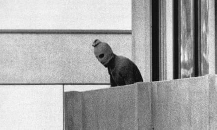 black-and-white image of person wearing mask, looking down