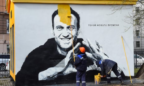 A worker paints over graffiti of the jailed Kremlin critic Alexei Navalny in Saint Petersburg last month. The inscription reads: ‘The hero of the new times.’