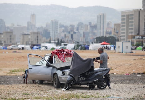 A man packs his belongings into a car from a makeshift shelter in Beirut.