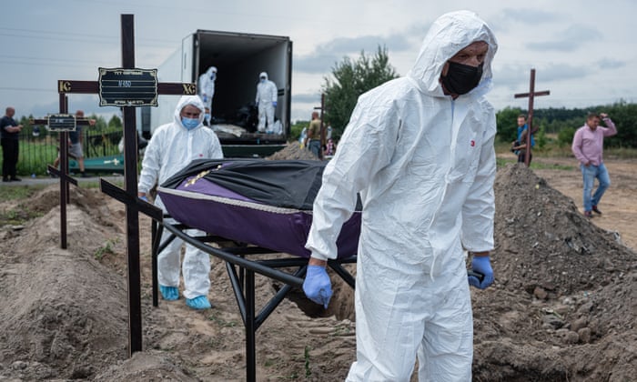 Workers carry a coffin with the body of an unidentified person killed during the Russian occupation of Bucha on 11 August.