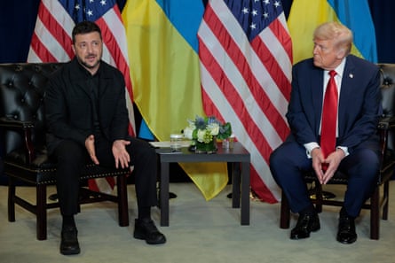 Zelenskky and Trump sit in front of the flags of their countries; Zelenskyy is speaking as Trump looks on.