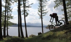 A cyclist, silhouetted against Loch Lochy, on the Great Glen Way near Ben Nevis in Scotland.