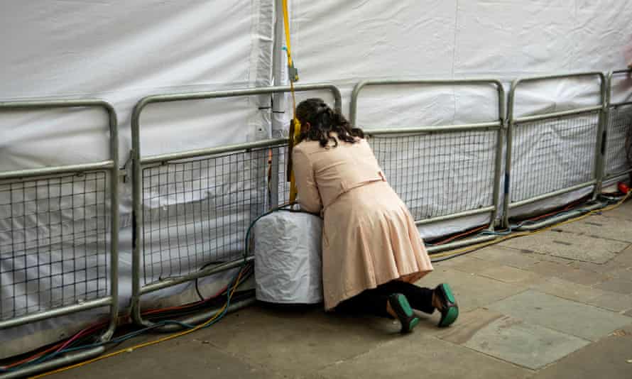 A woman peers through a media tent hoping to get a better view of the procession at St. Paul’s.