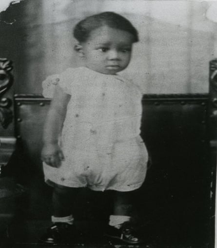 a black and white photo of a toddler standing