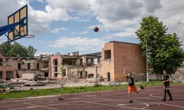 Children play basketball in Chernihiv in front of their school which was destroyed by Russian shelling.