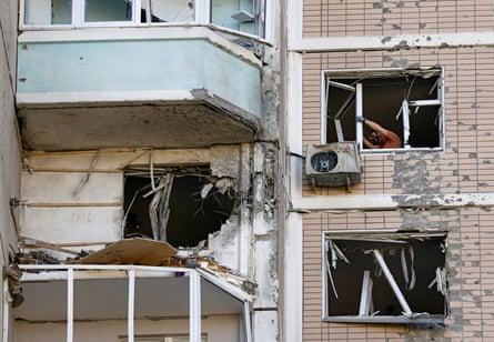Closeup of blown-out windows in apartment building in Moscow, with men pulling broken window frame out from the inside