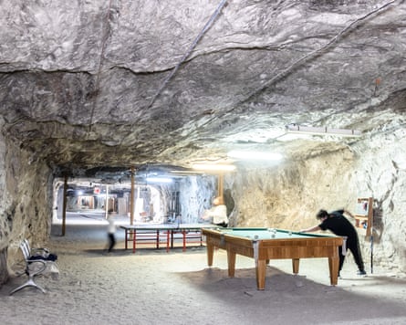 Billiards and table tennis tables in a large underground space.