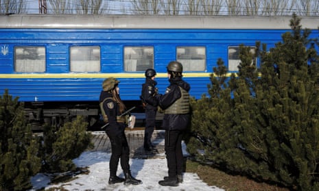Ukrainian police officers stand in front of an evacuation train.