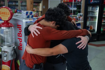 three family members hug inside of convenience store