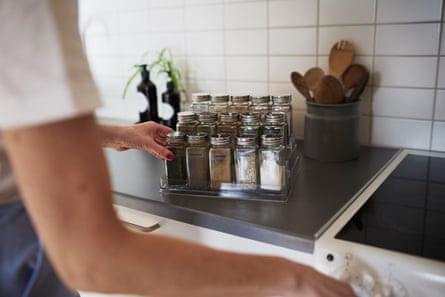 Woman’s hands checking spices connected herb rack