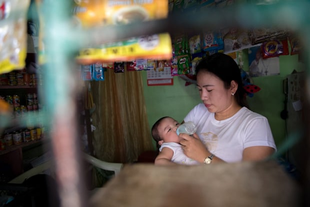 Jovelyn, 32, bottle feeds her five month-old baby JM in her home and shop in Caloocan City, Metro Manila, the Philippines.