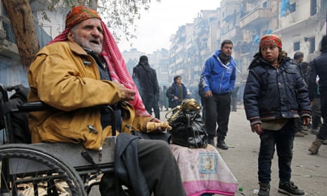 A man in a wheelchair eats as he waits to be evacuated from a rebel-held sector of eastern Aleppo, Syria.