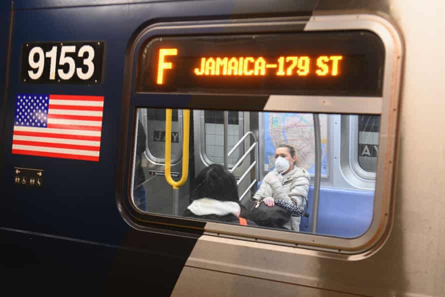 In this file photo taken on 17 March, 2020, a woman with a face mask rides on the subway in the Brooklyn Borough of New York City.