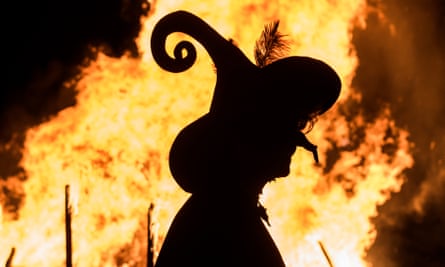 A woman dressed as a witch walks in front of a giant fire during the Walpurgis night celebrations in Erfurt, central Germany.