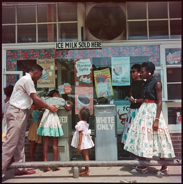 Untitled, At Segregated Drinking Fountain, Mobile, Alabama, 1956The Jim Crow laws established in the south ensured that public amenities remained racially segregated. These laws applied to schools, public transport, restaurants, recreational facilities and even drinking fountains. This image shows the prevalence of such prejudice, while capturing a scene of compassion. Here, a gentleman helps one of the young girls reach the fountain to have a refreshing drink.