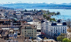 Zurich city view with mountains in the background on a clear, sunny day.