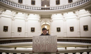 A man holds a sign inside the state capitol shortly after the electoral college cast their vote in Austin, Texas, putting Donald Trump over the 270 votes needed.