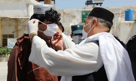 An Afghan tailor distributes free masks to the prisoners in Kandahar, Afghanistan.