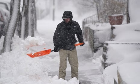 A man clears snow from the walkway of his home in Denver on Sunday.