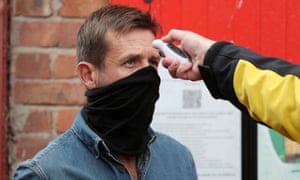 Former player Neil McCann has his temperature checked before entering the stadium.