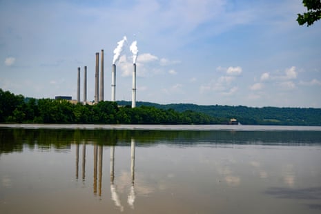 Smokestacks of a coal power plant rise above trees along the Ohio River in Maysville, Kentucky