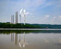 Smokestacks of a coal power plant rise above trees along the Ohio River in Maysville, Kentucky
