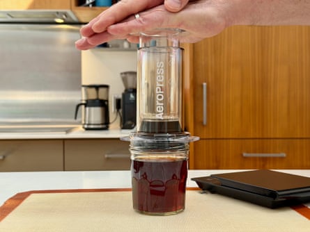A person making coffee with an aeropress clear