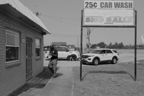 A man wearing a badge approached a door while holding documents