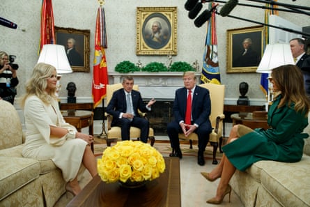 Four seated in the Oval Office with microphones around and flags behind