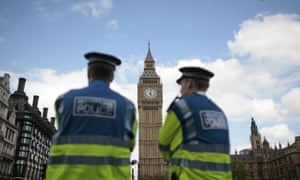 British police officers stand in front of the Houses of Parliament in central London