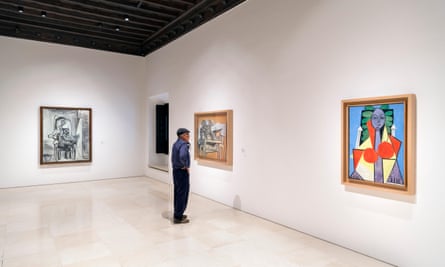 man looking at paintings in museum