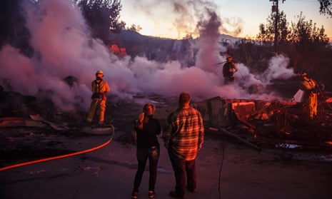 Firefighters mop up a burned down home destroyed by the Hillside fire in San Bernardino, 31 October 2019.