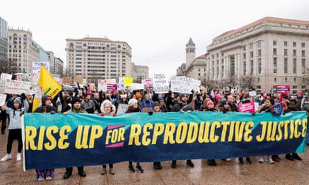 people hold banner saying 'rise up for reproductive rights'