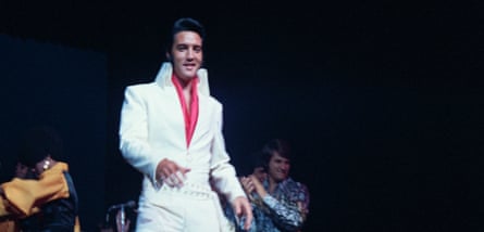 Elvis Presley wearing a white suit on stage