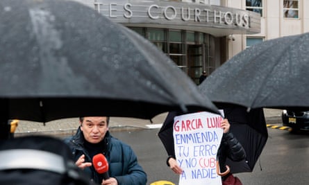 A woman with a sign stands near TV reporters in front the federal courthouse Brooklyn, New York on Monday.