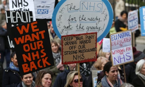 People take part in a demonstration to demand more funding for Britain’s NHS.